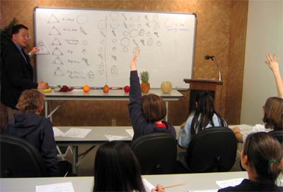 Students in classroom with hands raised